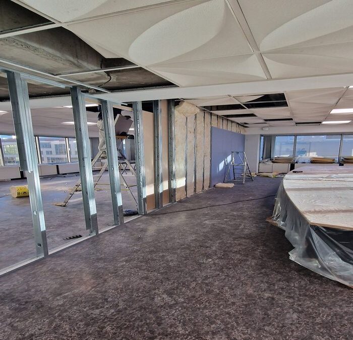 Ossature métallique de cloisons montée sur un plateau de bureaux, plafond partiellement déposé