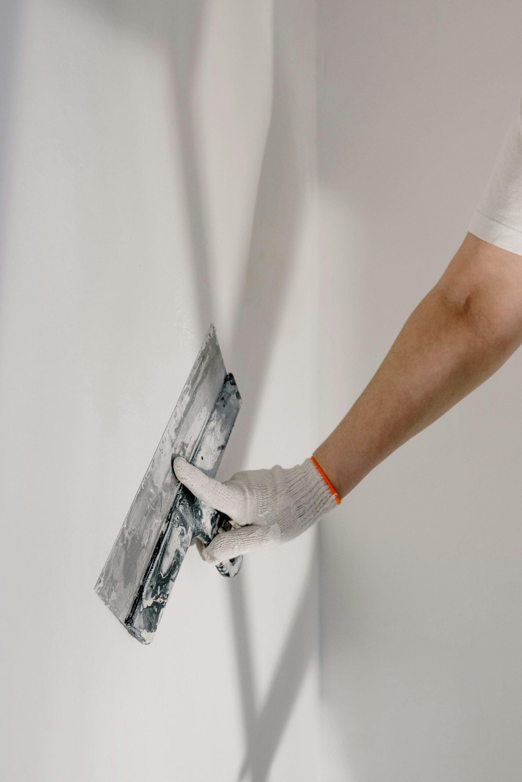 Artisan préparant un mur avant peinture